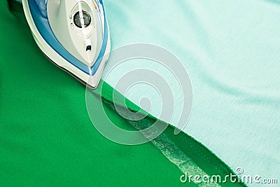 Hemming, shortening green courtain fabric with an adhesive iron-on hemming tape Stock Photo