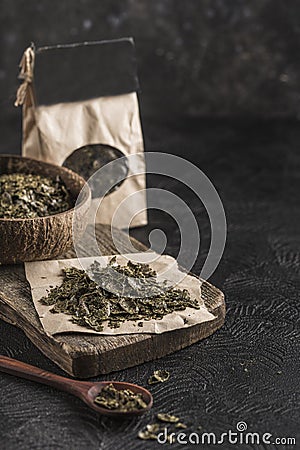Hemp flakes in a coconut bowl for healthy food on a wooden Board on a black background Stock Photo