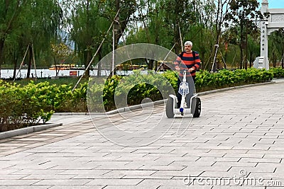 A tourist on a segway in the city of Hengdian film and television, in Zhejiang province, China Editorial Stock Photo