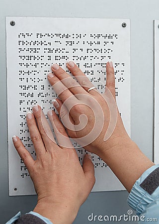 Her hands reading Braille table Stock Photo