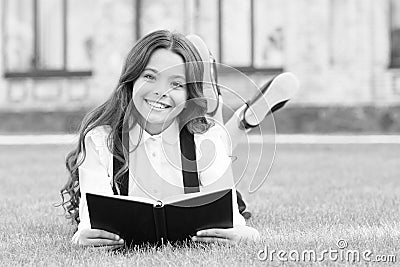 Her hobby is literature. Happy small child read childrens literature outdoor. Adorable little girl enjoy reading English Stock Photo