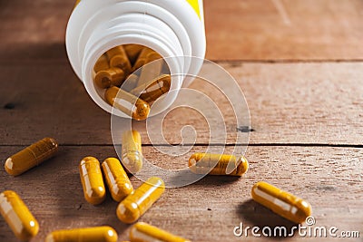 Herb capsule spilling out of a bottle in still life Stock Photo