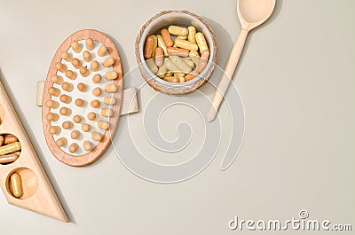 Herb in capsules in wooden bowl on pastel beige background. Beauty products for face and body skin care Stock Photo