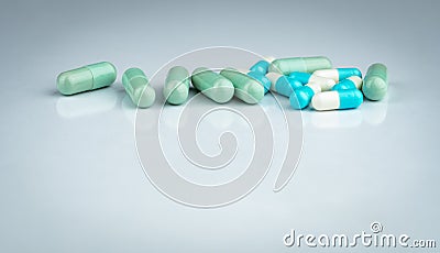 Herbal and drug interactions. Green and blue capsule pill on white background. Herbal medicine. Pharmaceutical industry. Pharmacy Stock Photo