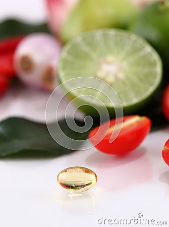 Herbal medicine oil pills on vegetable background. Stock Photo