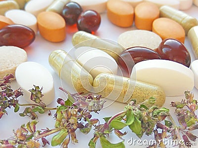 Herbal medicine pills with dry natural herbs on white background. Concept of herbal medicine and dietary supplements Stock Photo