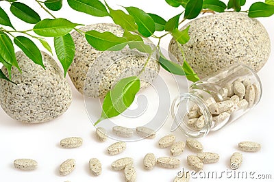 Herbal supplement pills spilling out of bottle Stock Photo