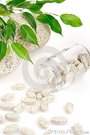 Herbal supplement pills spilling out of bottle Stock Photo