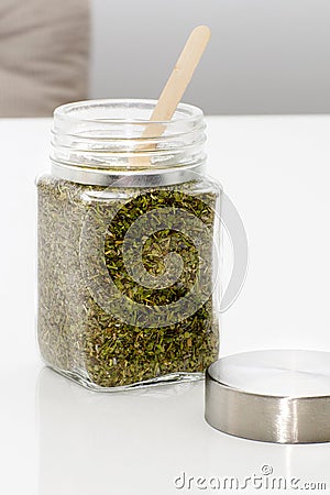 Herbs are in the glass jars with spoons. Stock Photo