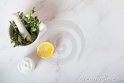 Herbs in a mortar, soap and cream with lemon on a white background Stock Photo