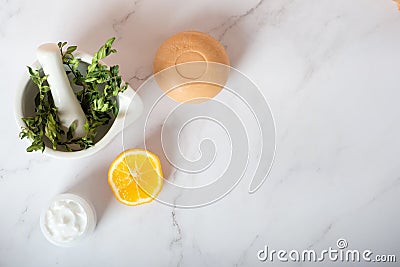 Herbs in a mortar, soap and cream with lemon on a white background Stock Photo