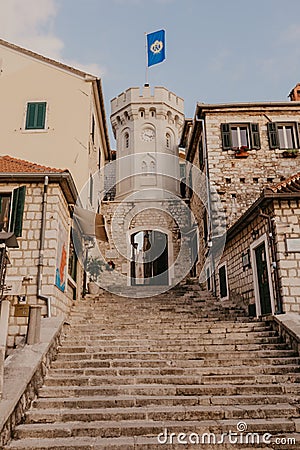 HERCEG NOVI, MONTENEGRO - November 30, 2018: the old town gate with the small clocktower surrounded by old houses, cafes and bars Editorial Stock Photo