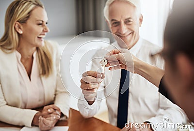 Here is your keys to the castle. a cheerful mature couple receiving keys from a real estate agent to their new house Stock Photo