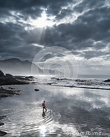 Hermanus, South Africa - Man in tidal pool reflecting the sky at dusk Editorial Stock Photo
