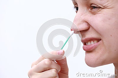 Herpes on the nose - Pretty young woman woman holding an ear stick with herpes medicine. Human Virus. Close Up of Nose with herpes Stock Photo
