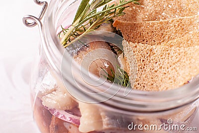 Herring and rye toast. In the glass jar, the original feed. traditional Danish sandwich with a young herring. Stock Photo