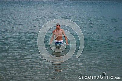 09.20.2008, Hersonissos, Crete, Greece. A young man standing in the water at the coast. Editorial Stock Photo