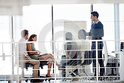 Hes acing this presentation. a group of colleagues brainstorming in an office. Stock Photo