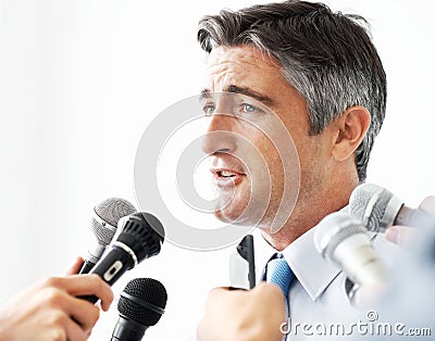 Hes an eloquent spokesperson. Handsome mature businessman being interviewed against a white background. Stock Photo