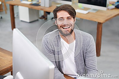 Hes a go-getter. Portrait of a handsome young man sitting at his office desk. Stock Photo