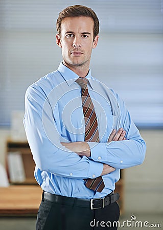 Hes got ambition. A young businessman standing and looking confidently at the camera with his arms folded. Stock Photo