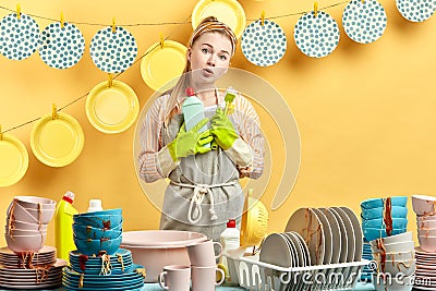 Hesitant displeased surprised girl holds brush and cleaning liquid Stock Photo