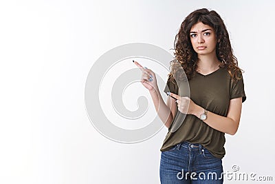 Hesitant displeased suspicious intense cute armenian girl have bad feeling frowning pouting doubtful pointing left index Stock Photo