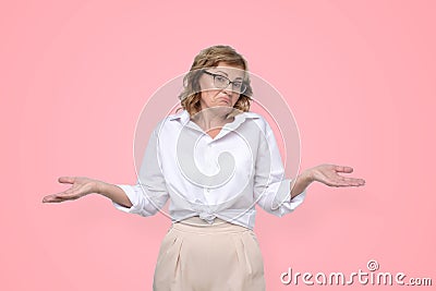 Hesitant mature caucasian bossy woman shrug shoulders, looks uncertain and confused Stock Photo