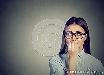 Hesitant woman biting her fingernails craving for something or anxious Stock Photo