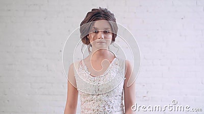 Het aantrekkelijke beeld van donker-haired bruid met keurig, zacht kapsel, gaat en bekijkt direct camera, die in lang spinnen stock video Het aantrekkelijke beeld van donker-haired bruid met keurig, zacht kapsel, gaat en bekijkt direct camera, die in lang spinnen stock video