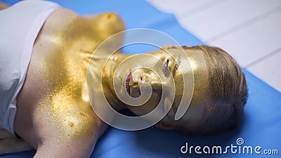 Het gieten van het gloeien fonkelt aan het gezicht van de vrouw voor bodyartproject, bodyart installatie, het maken van glanzend stock videobeelden Het gieten van het gloeien fonkelt aan het gezicht van de vrouw voor bodyartproject, bodyart installatie, het maken van glanzend stock videobeelden