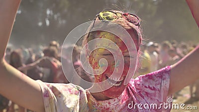 Het jonge gelukkige meisje in kleurrijk poeder lacht histerically en danst op holifestival in dag in de zomer stock footage Het jonge gelukkige meisje in kleurrijk poeder lacht histerically en danst op holifestival in dag in de zomer stock footage
