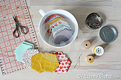 Hexagon patchwork templates, white cup, thread, retro scissors, metal pins and quilting ruler Stock Photo
