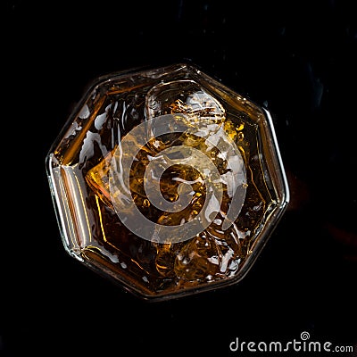 Hexagonal glass of whiskey with three cubes of real ice top view Stock Photo