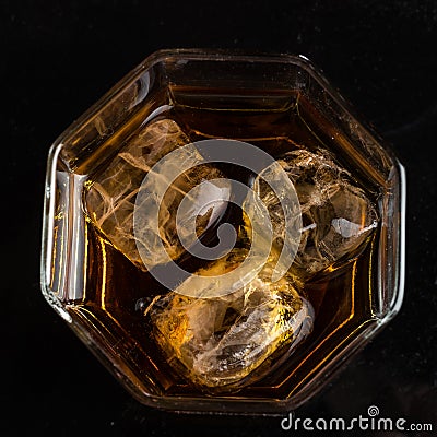 Hexagonal glass of whiskey with three cubes of real ice top view Stock Photo