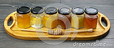 Hexagonal jars with different types and colors of fresh flower honey and a honey spoon. vitamin food for health and life Stock Photo