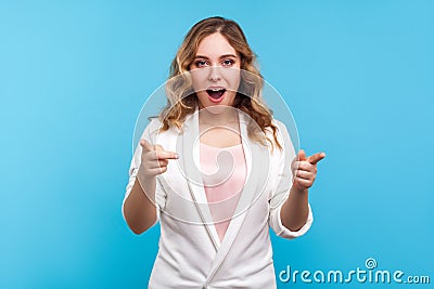Hey, you are awesome! Portrait of pleasantly surprised woman pointing at camera with shocked face. blue background Stock Photo