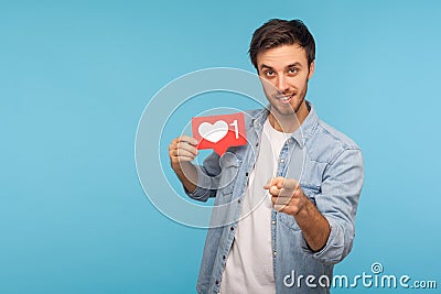 Hey you, click Like! Portrait of handsome blogger man in denim shirt holding social media heart Like button Stock Photo
