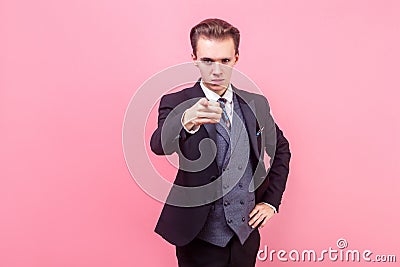Hey you! Portrait of irritated bossy young businessman in tuxedo pointing at camera. studio shot isolated on pink background Stock Photo