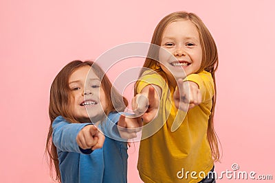 Hey you! Two charming happy little girls pointing to camera, indicating lucky one and smiling Stock Photo