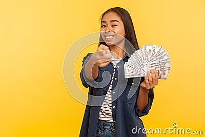 Hey you, want big profit? Portrait of rich happy satisfied woman holding dollar banknotes and pointing to camera Stock Photo