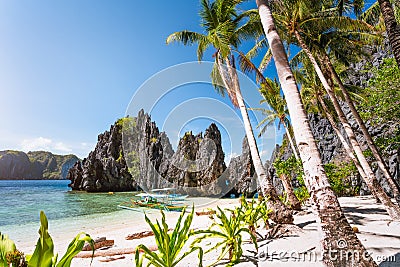 Hidden beach with first tourist trip boats in morning sun light at El Nido, Palawan, Philippines Stock Photo