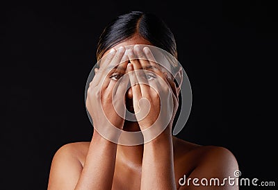 Hiding, shame and portrait of a woman covering face on a black background in a studio. Shy, fear and girl with Stock Photo