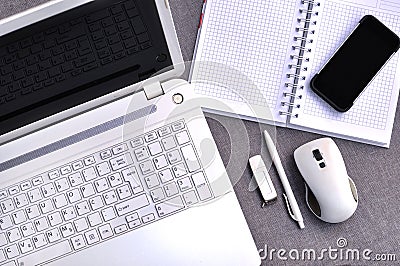 High above view of office workplace with mobile phone and laptop close up computer keyboard and mouse with notebook, pen and usb Stock Photo