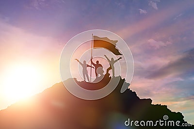 High achiever, silhouettes of three people holding on top of a mountain to raise their hands up. Stock Photo