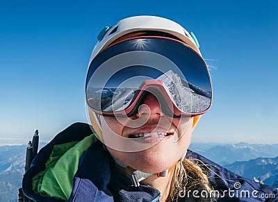High altitude mountaineer smiling female portrait in safe ski helmet and goggles on the Mont Blanc 4810m with picturesque Alpine Stock Photo
