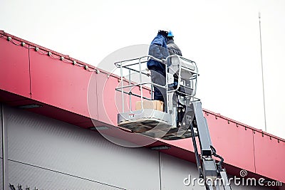 High-altitude works. Professional installation work on a construction building site. Assemblers perform high-altitude installation Editorial Stock Photo