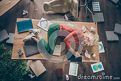 High angle above view photo of corporate messy atmosphere unorganized blond business lady lying table don`t mind Stock Photo