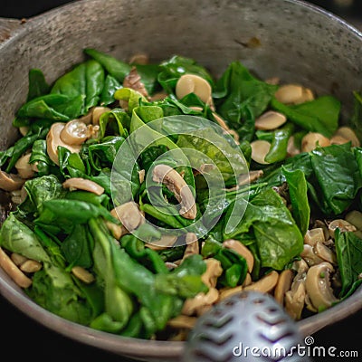 High angle closeup of a spinach mushroom salad in a bowl Stock Photo