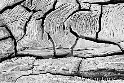 High angle greyscale shot of a stony cracked ground with some traces on it Stock Photo